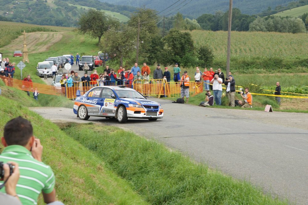 Před páskou mohou být pouze pořadatelé (zde v oranžové vestě) a akreditovaní fotografové (zde mají bílé vesty). Diváci jsou spořádaně za zábranami či na svazích.