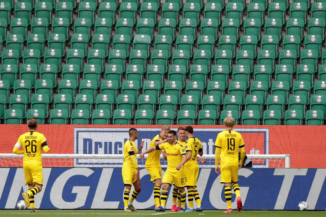 Hráči Borussie Dortmund se radují z gólu Raphaela Guerreira před prázdnými tribunami