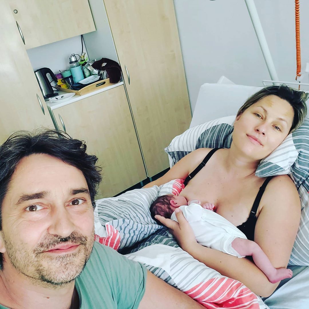 Šťastný táta s manželkou a jejich novorozenou dcerou.