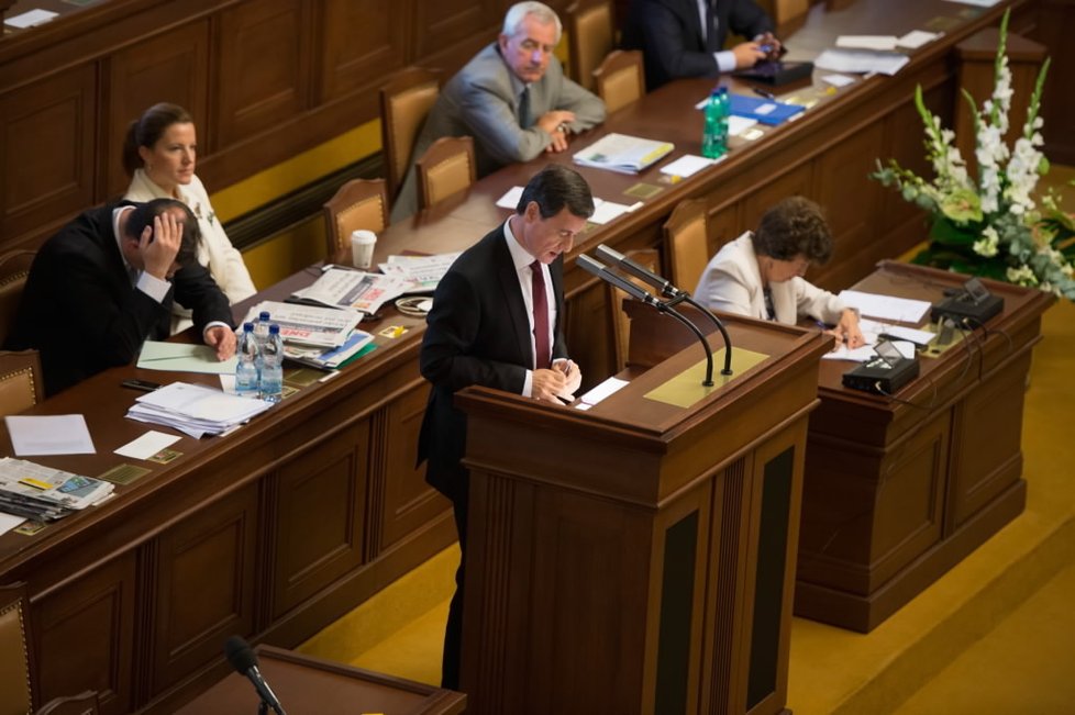 Premiér Petr Nečas, který sedí přímo za Rathem, má hlavu v dlaních