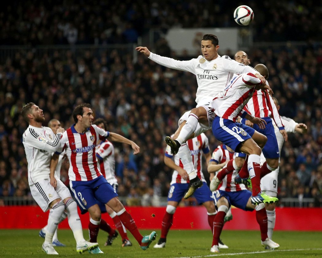 Hvězda Realu Madrid Cristiano Ronaldo v hlavičkovém souboji s obráncem Atlética Mirandou