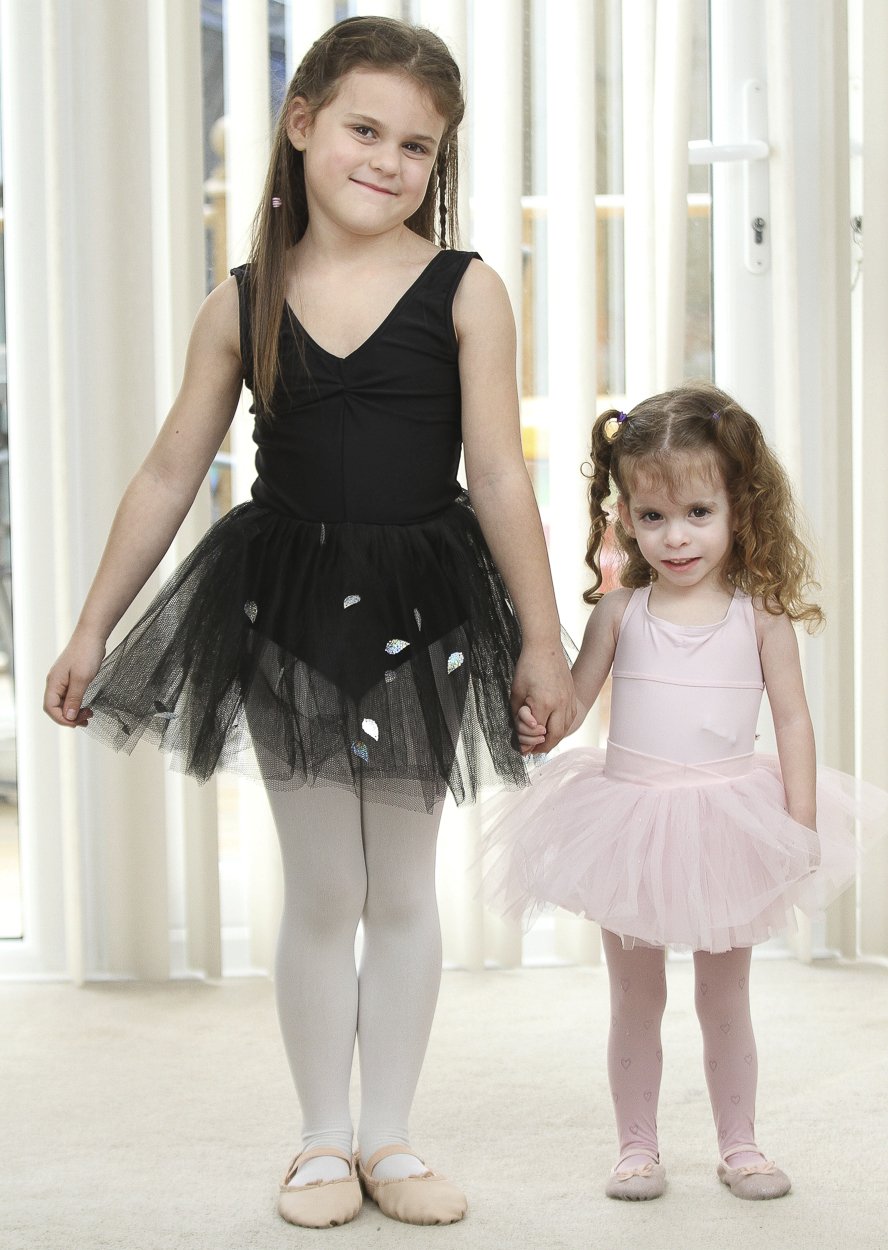 Holčička chodí se svojí sestrou na balet.