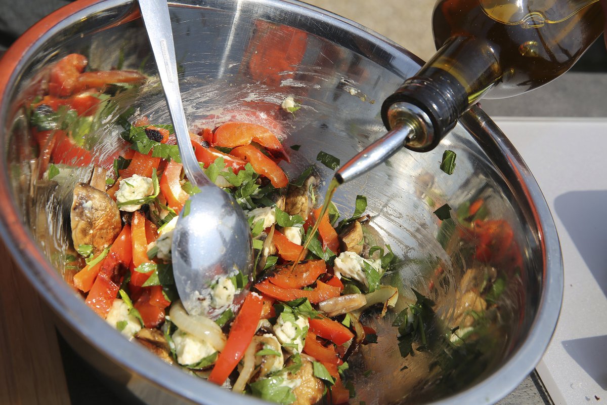 Salát zakápneme olivovým olejem. Na talíř dáváme vždy trochu salátu, plněné žampiony a kousky slaniny. 