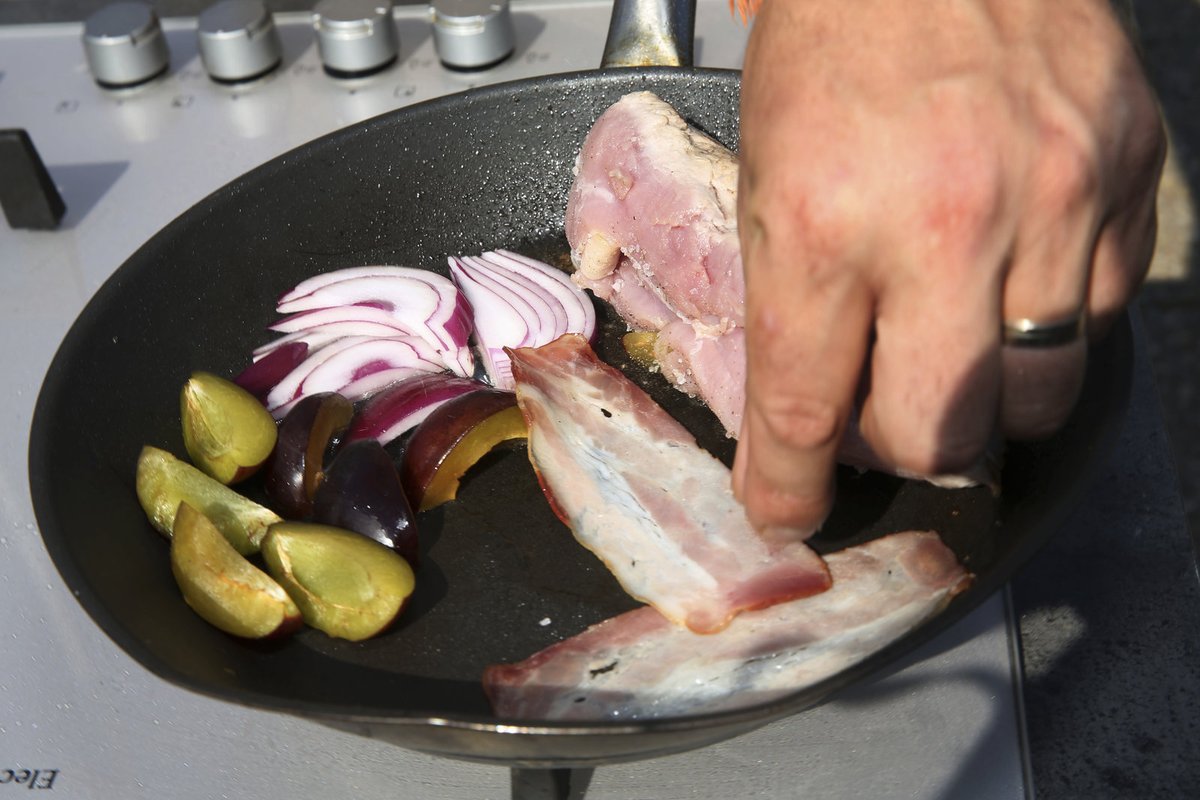 Po opečení přidáme do pánve zbylé švestky, na měsíčky nakrájenou cibuli a plátky slaniny.