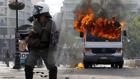 Před hořící dodávkou brání policta svoji pozice.