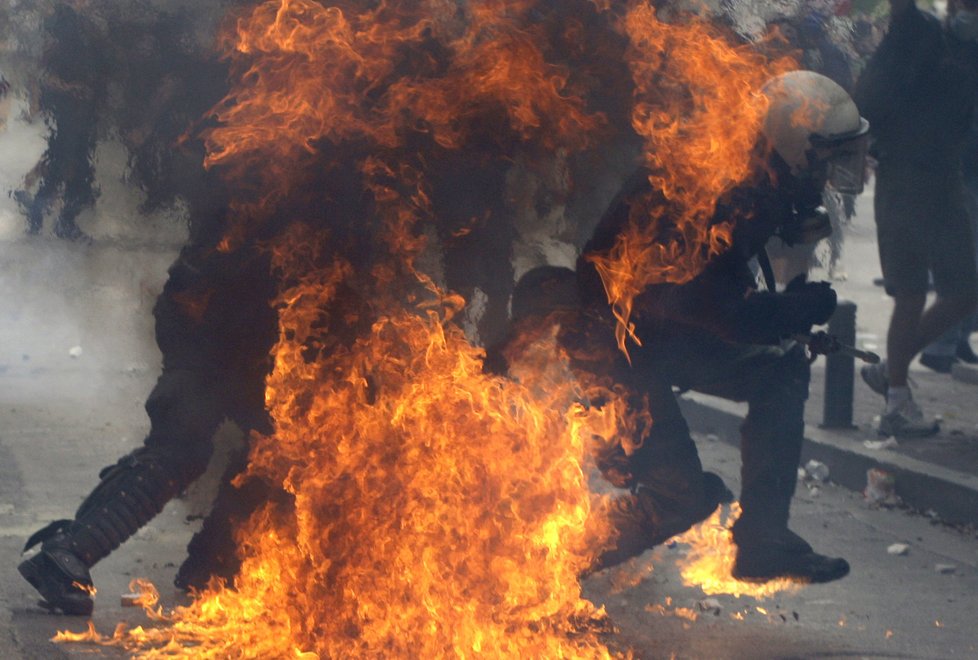 Hořící policista se snaží uprchnout před plameny.