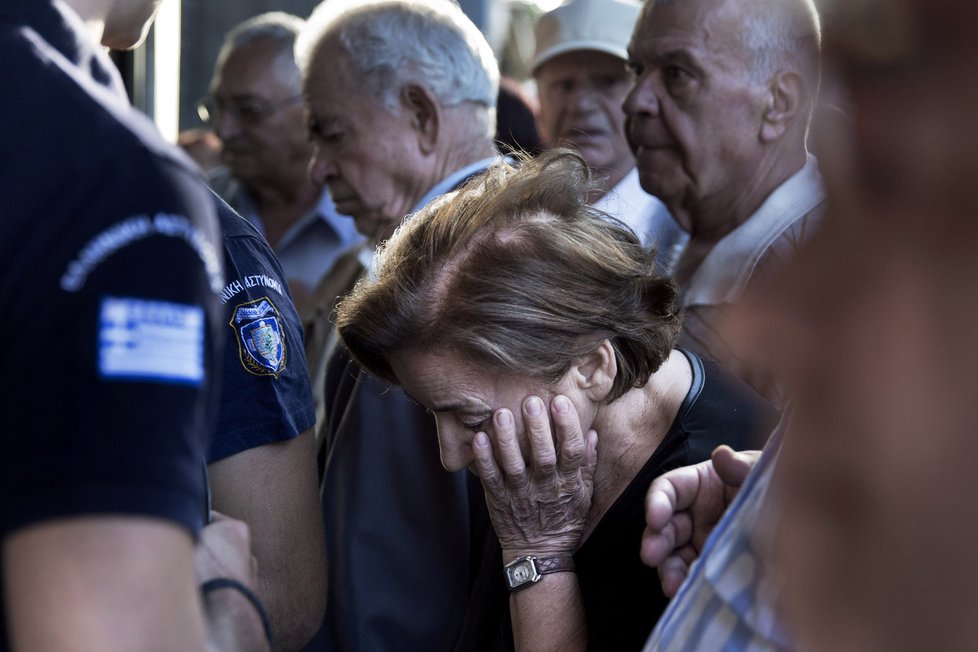 Smutné obličeje seniorů v tlačenici před bankou v Athénách