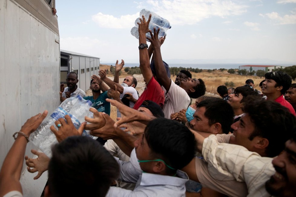 Migranti z tábora Moria na řeckém ostrově Lesbos dostali balenou pitnou vodu. (12. 9. 2020)