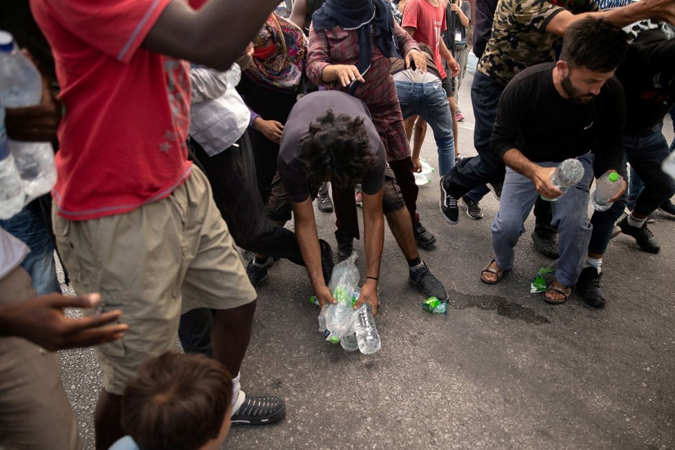 Migranti z tábora Moria na řeckém ostrově Lesbos dostali balenou pitnou vodu (12. 9. 2020).