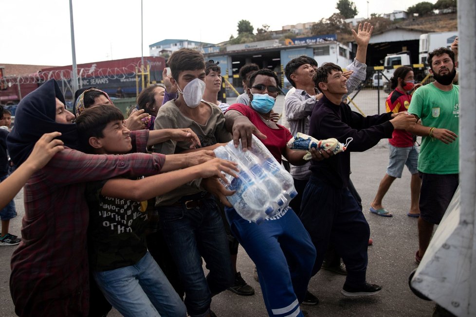 Migranti z tábora Moria na řeckém ostrově Lesbos dostali balenou pitnou vodu. (12. 9. 2020)