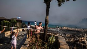 Němečtí turisté pomáhají s hašením požáru u resortu Lindos na Rhodu (24. 7. 2023).