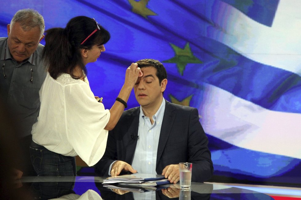 Řecký premiér Alexis Tsipras před televizním interview pro řeckou televizi ERT. Maskérka před vysíláním zakrývá jeho zpocené čelo.