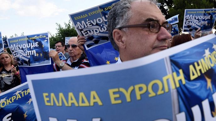 řecký demonstrant drží plakát s nápisem: Řecko, Evropa, demokracie - zůstaneme v Evropě.