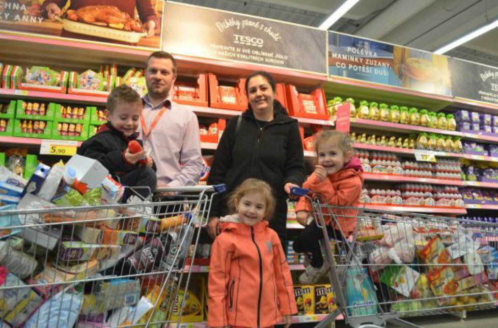 Paní Renata s trojčaty a ředitelem supermarketu Tomášem Cvekem. Ten jim předal dva plné koše zboží, především potravin a pracích prášků.