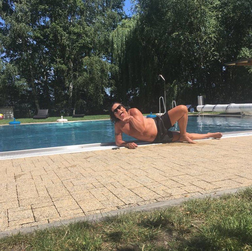 Richard Genzer pózuje jako modelky u bazénu.