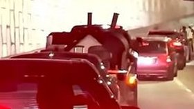 Auto přeletělo přes zábradlí a zůstalo viset nad silnicí. Z vozu trčely nohy řidiče.