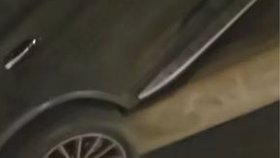 Auto přeletělo přes zábradlí a zůstalo viset nad silnicí. Z vozu trčely nohy řidiče.