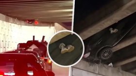 Auto přeletělo přes zábradlí a zůstalo viset nad silnicí. Z vozu trčely nohy řidiče.