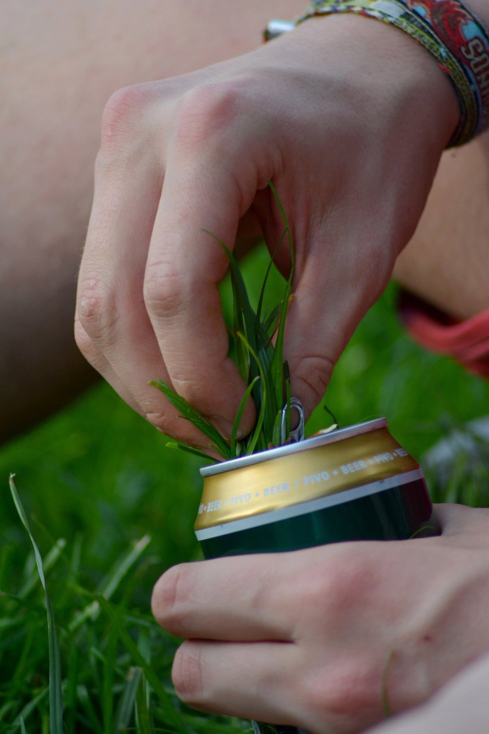 Hraní si s trávou a prázdnou plechovkou od piva