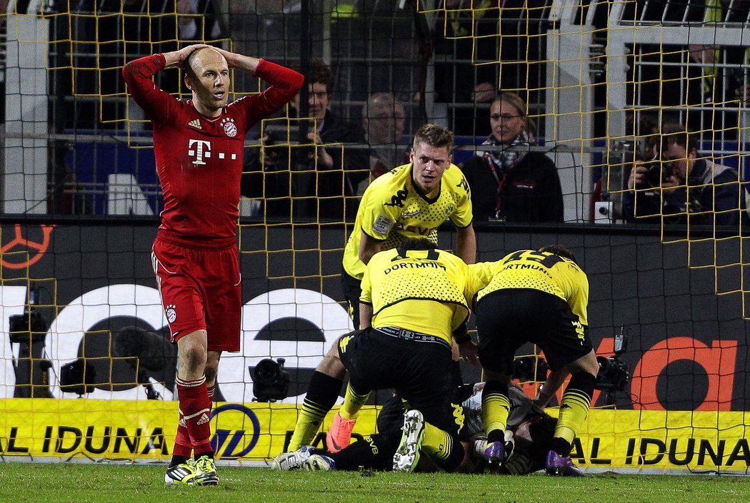 Arjen Robben zklamaně kráčí, hráči Dortmundu oslavují svého brankáře.
