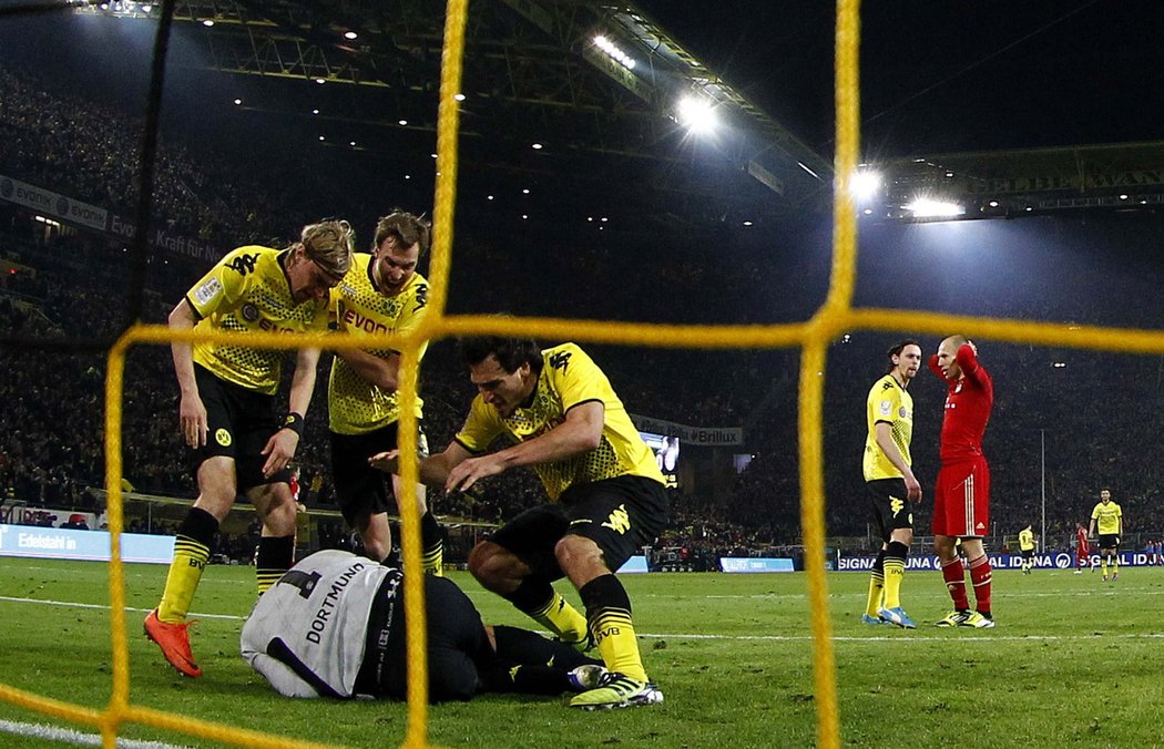 Arjen Robben se zklamaně drží za hlavu, hráči Dortmundu oslavují svého brankáře.