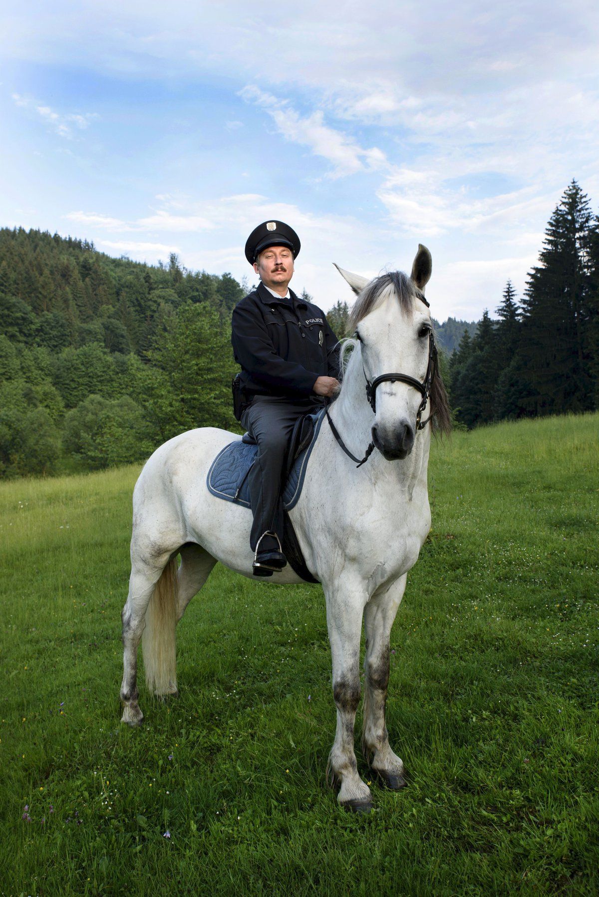 Strážmistr Topinka pózuje na běloušovi.