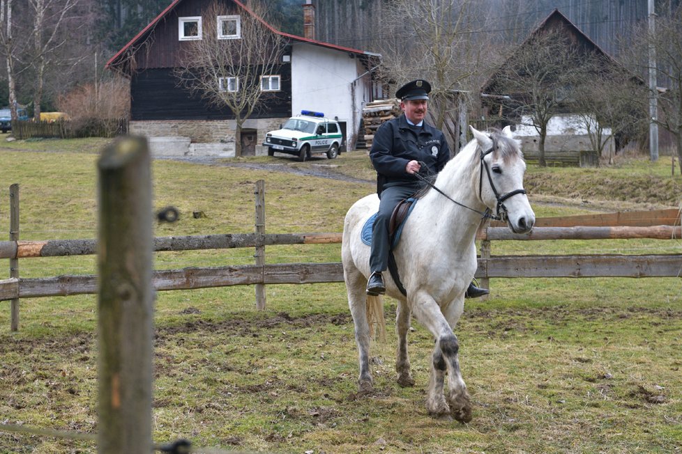 Strážmistr Topinka pózuje na běloušovi.