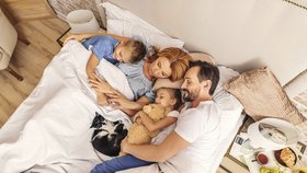 Děti spí s rodiči v jedné posteli.