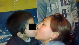 Žena si nechá dávat od chlapce polibek na rty.