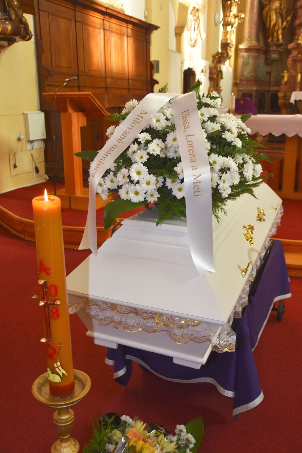 Při pohřbu zastřelené ženy (+37) byl plný kostel smutečních věnců a květin.