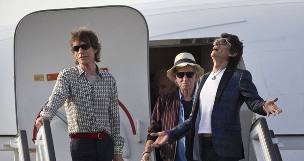 Ron Wood, Keith Richards a Mick Jagger vystupují z letadla.