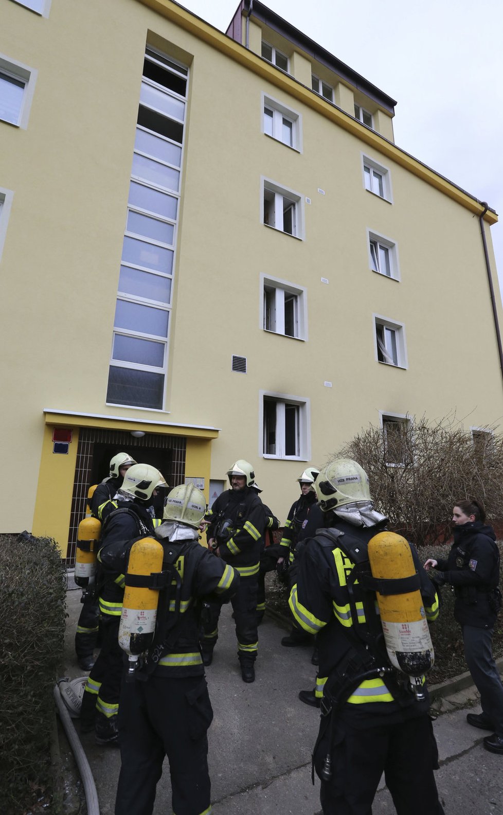 Hasiči jdou do domu i s kyslíkovými bombami na zádech.