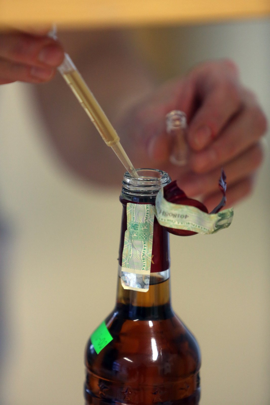 14:35 - Z láhve pak laborantka »rum« opatrně odebere pipetou a vzorek přelije do malé ampulky, která poputuje do laboratoře.