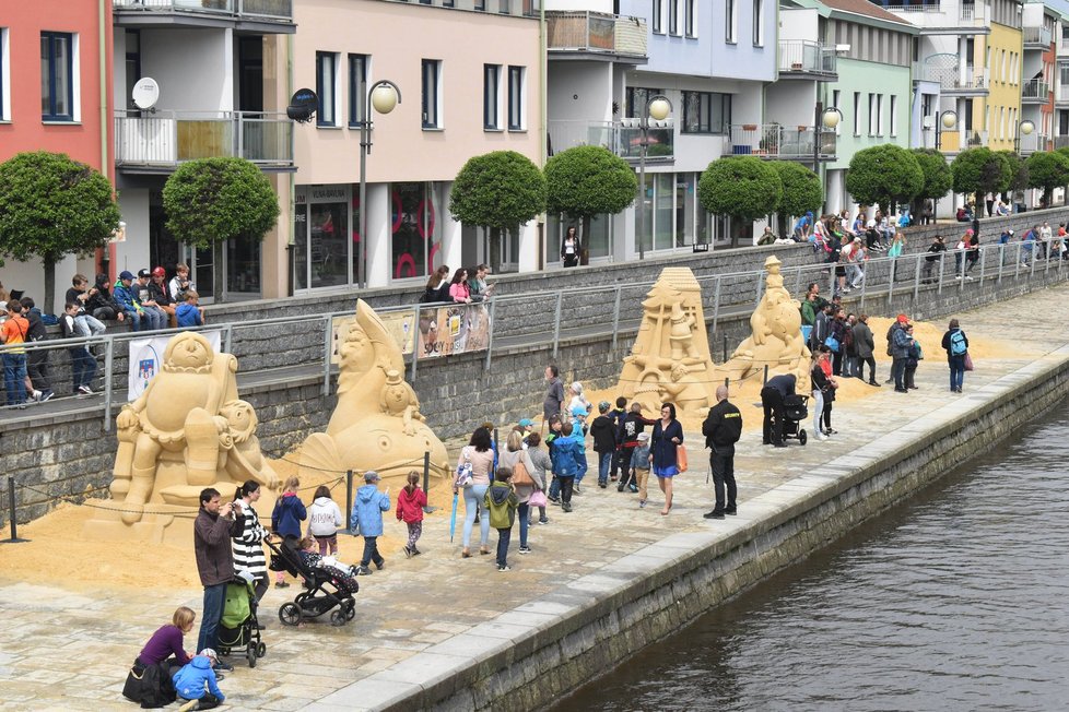 Obří sochy z písku, které zachycují výjevy ze života loupežníka Rumcajse, zdobí náplavku řeky Otavy v Písku.