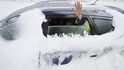 Rumunský řidič mává z auta uvězněného ve sněhu