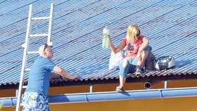 Po čtyřech hodinách žena slezla zpět na střechu. Jeden z vyjednavačů vylézá po žebříku za ní.