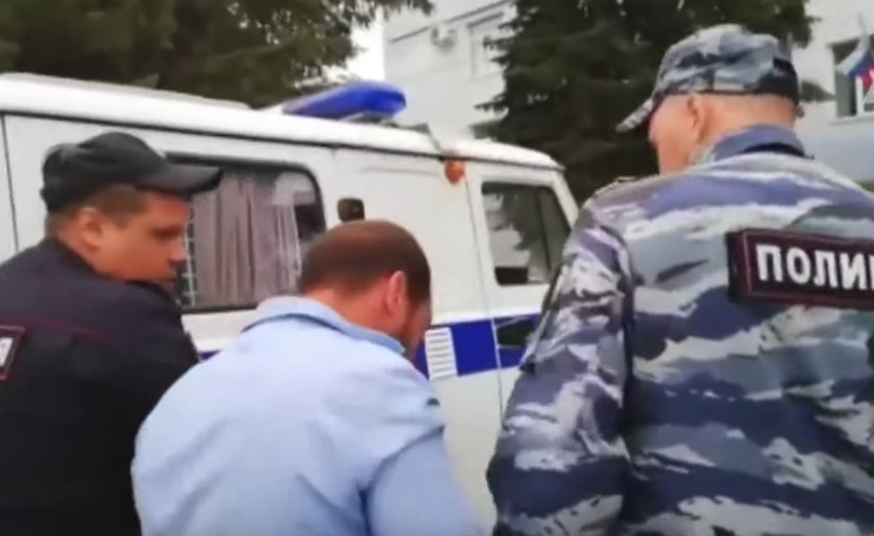 Ruští policisté odvádějí jednoho ze zadržených