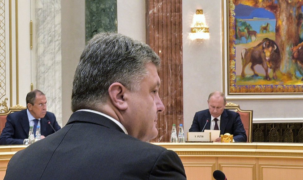 Petro Porošenko v popředí, na druhém konci jednacího stolu Vladimir Putin