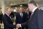 Putin si potřásl rukou s Porošenkem, ale úsměv působil poněkud nepatřičně.