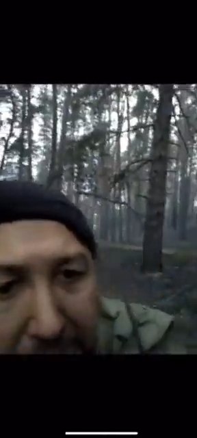 Ukrajinský voják natáčí video, zatímco se kolem něj ozývají výstřely.