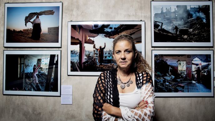 Heidi Levineová  na vernisáži své pražské výstavy, která skončila v půli listopadu. Za ní snímky trosek pořízené v Gaze.