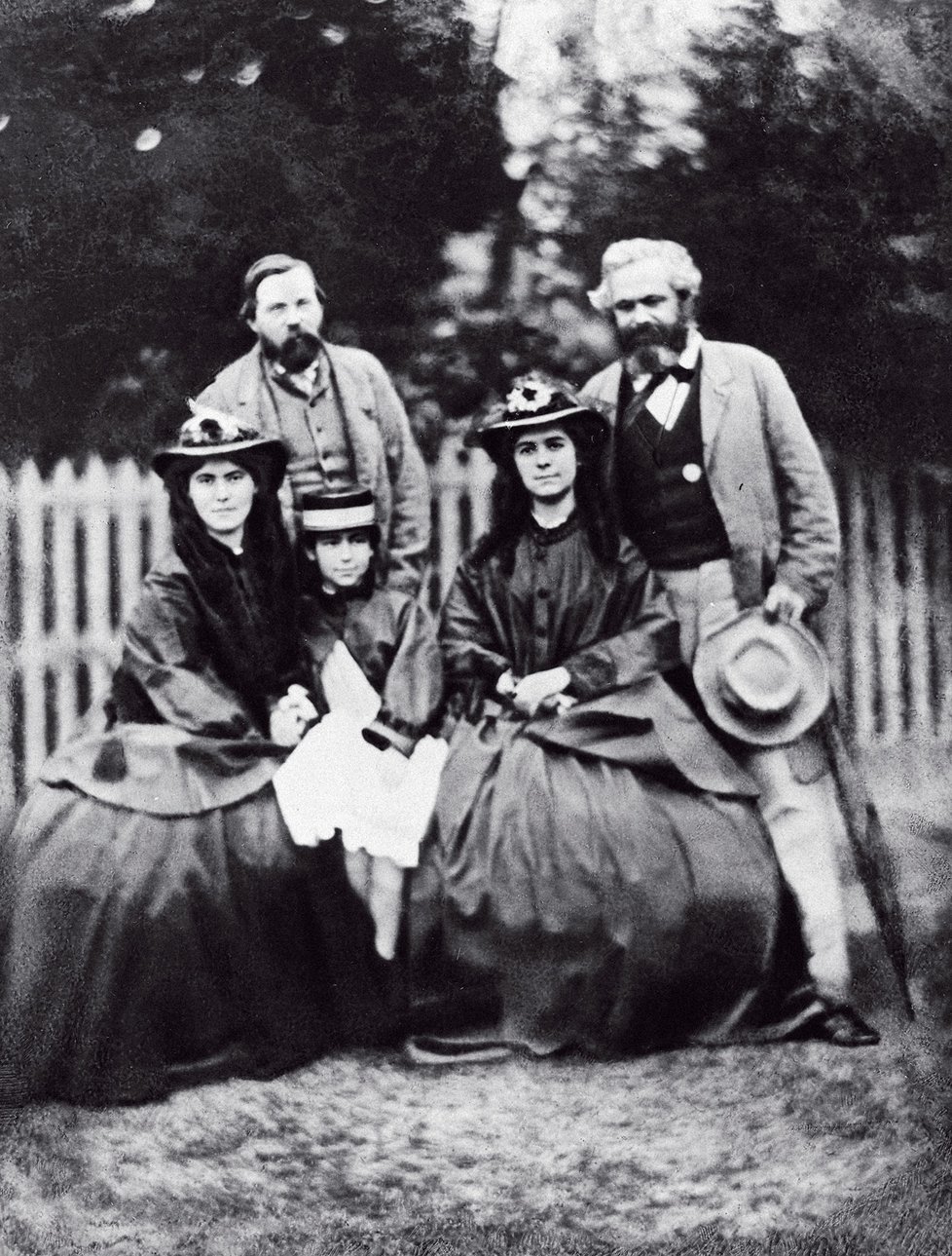 Marxova rodina v&nbsp;roce 1864. Zleva Bedřich Engels, dcery Jenny, Eleonora a&nbsp;Laura, vpravo sám Marx.
