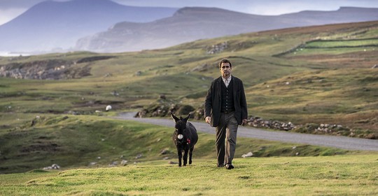 Pádraic (Colin Farrell), jeho oslice Jenny a irská krajina hrající všemi odstíny zelené