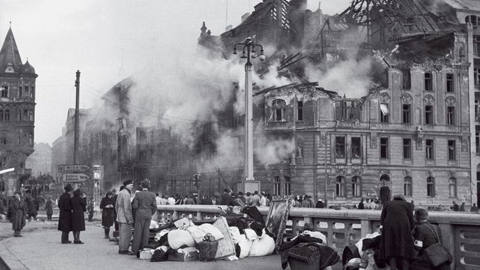 Lidé zachraňují zbytky majetku po bombardování.  Na tomto místě dnes stojí Tančící dům.