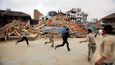 Následné otřesy. Obyvatele Nepálu minulou neděli vyděsily i následné otřesy, jež přišly jako dozvuk sobotního zemětřesení. Na fotografii jsou dobrovolníci v metropoli Káthmándú, kteří spěchají kolem trosek k dalším zraněným.