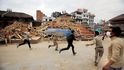 Následné otřesy. Obyvatele Nepálu minulou neděli vyděsily i následné otřesy, jež přišly jako dozvuk sobotního zemětřesení. Na fotografii jsou dobrovolníci v metropoli Káthmándú, kteří spěchají kolem trosek k dalším zraněným.