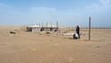 Afričtí nádeníci stavějí první stany pro kempovací sezónu v poušti. Ještě nezačala, a už se kolem válejí odpadky. 