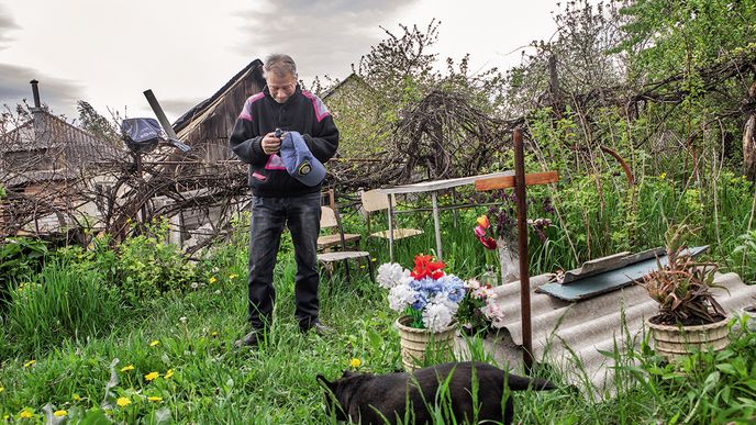Dmytro z ukrajinské vesnice Cyrkuny u hrobu své ženy, kterou pohřbil na zahradě