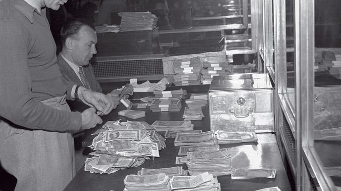 Bankovní úředníci přepočítávají staré peníze, které lidé odevzdali v rámci měnové reformy. Tu schválilo Národní shromáždění v sobotu 30. května 1953. Do dějin tato událost vystoupí jako velká loupež.