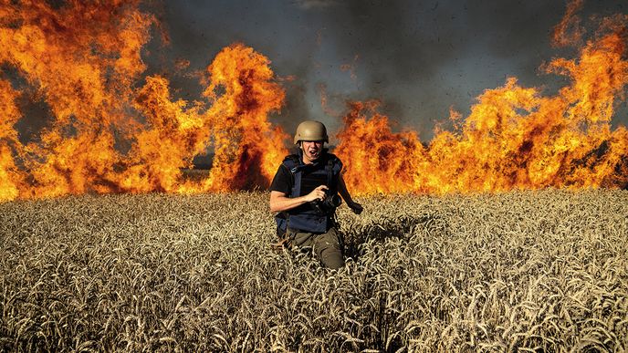 Fotoreportér utíká před plameny v pšeničném poli hořícím po ruském ostřelování v Charkovské oblasti